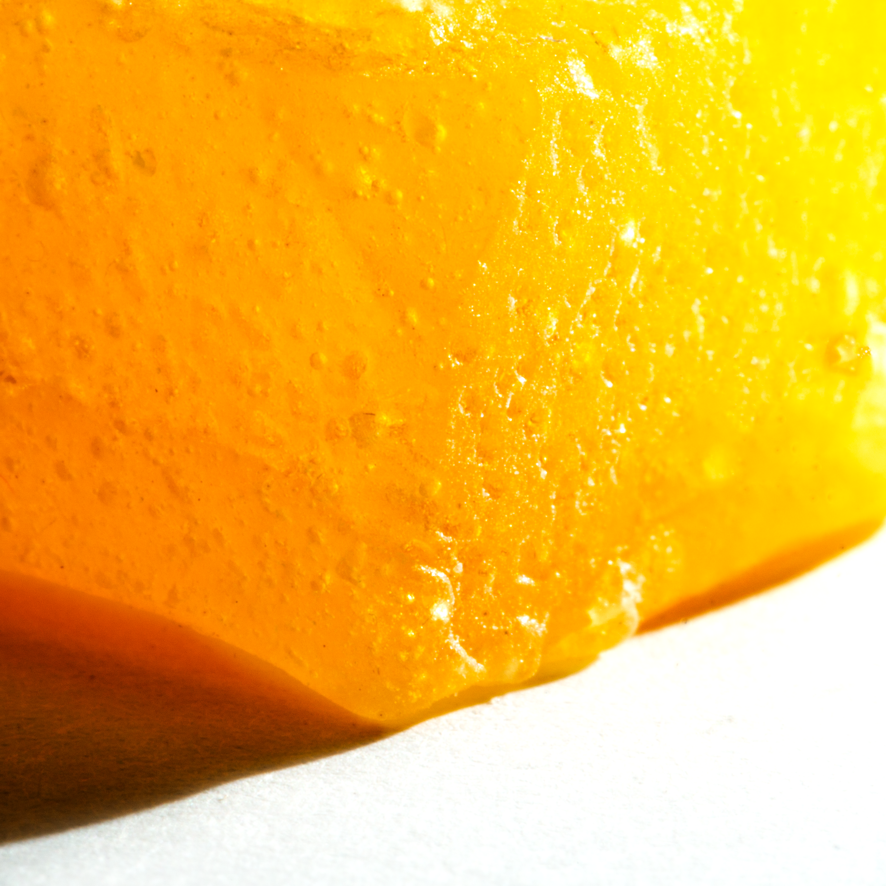 Close-up of a yellow gummy candy on a white background