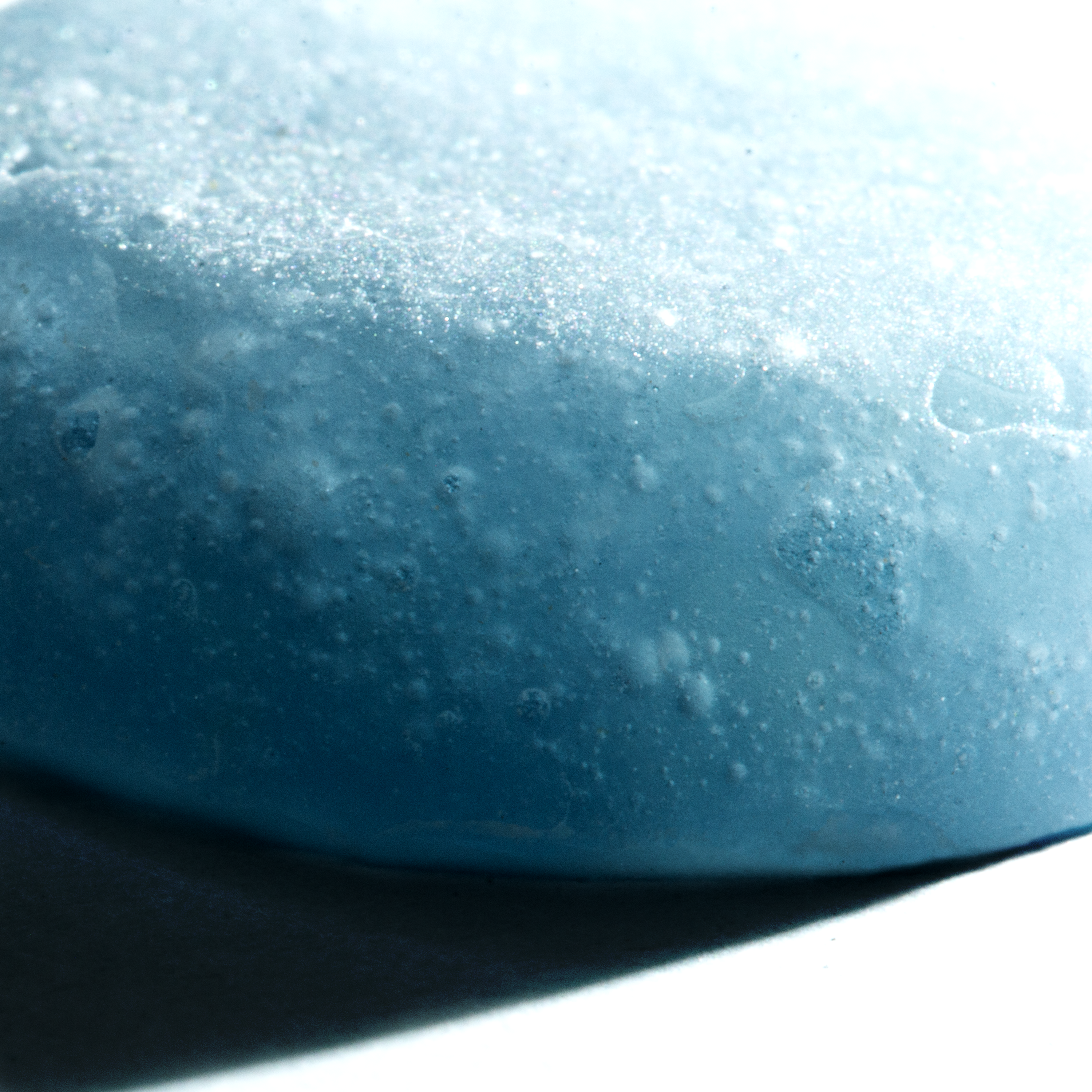 Close-up of a textured blue gummy candy on a white background